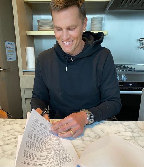 Tom Brady firmando su nuevo contrato con los Tampa Bay Bucaneers.